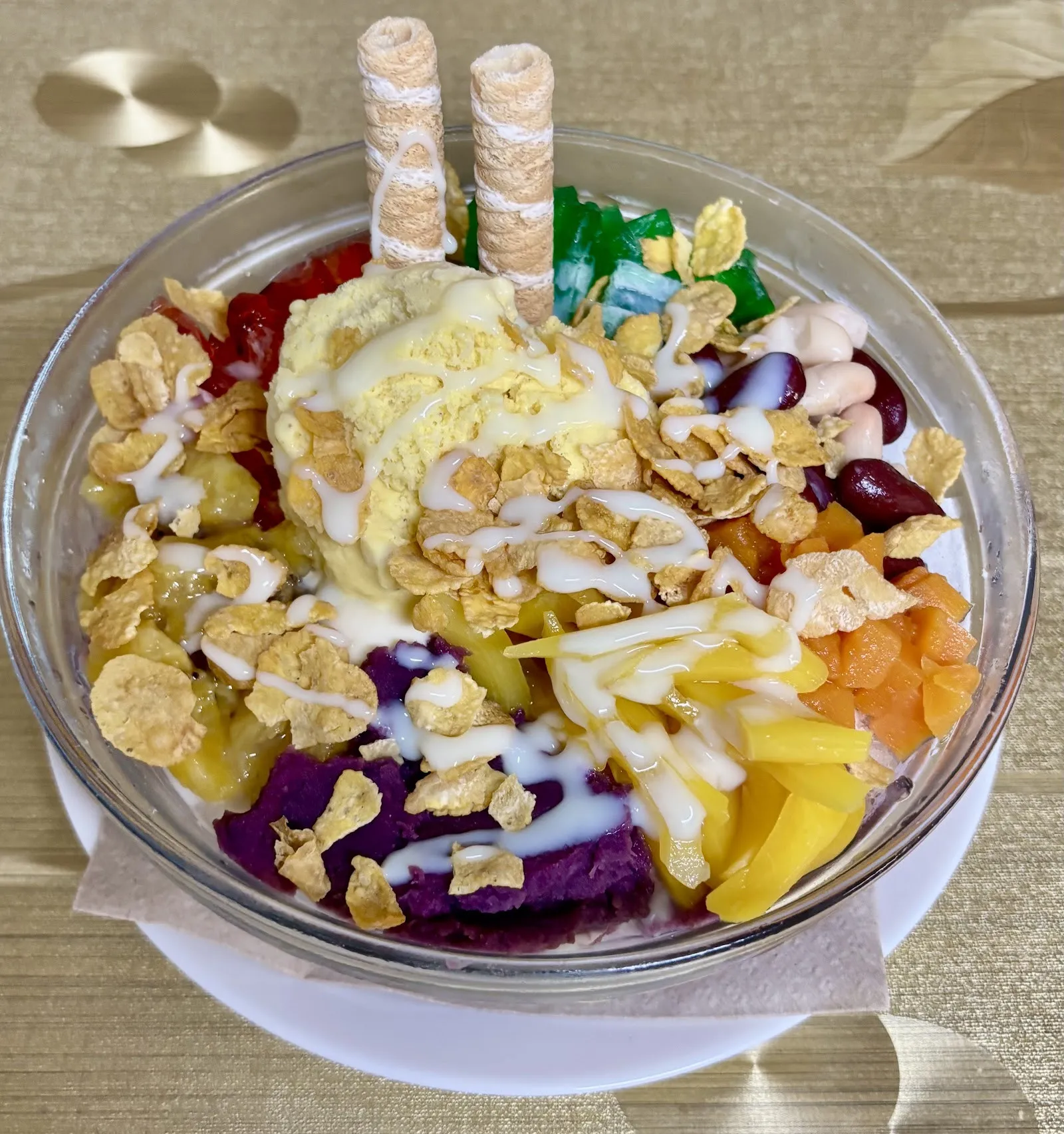 Postre de hielo picado con frutas de colores y barquillos