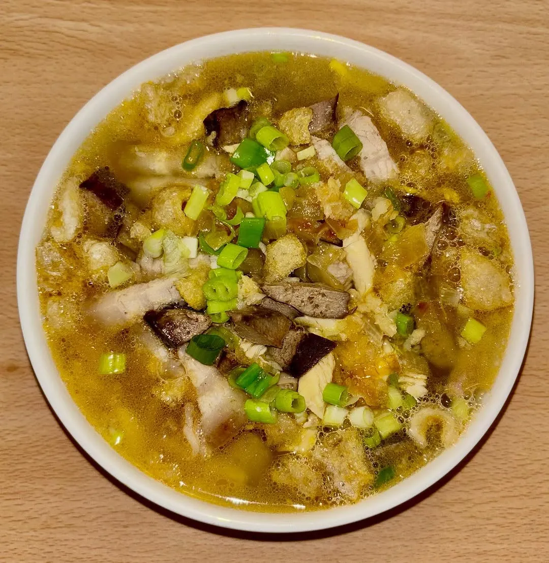 Un bol de La Paz Batchoy con cebolleta por encima